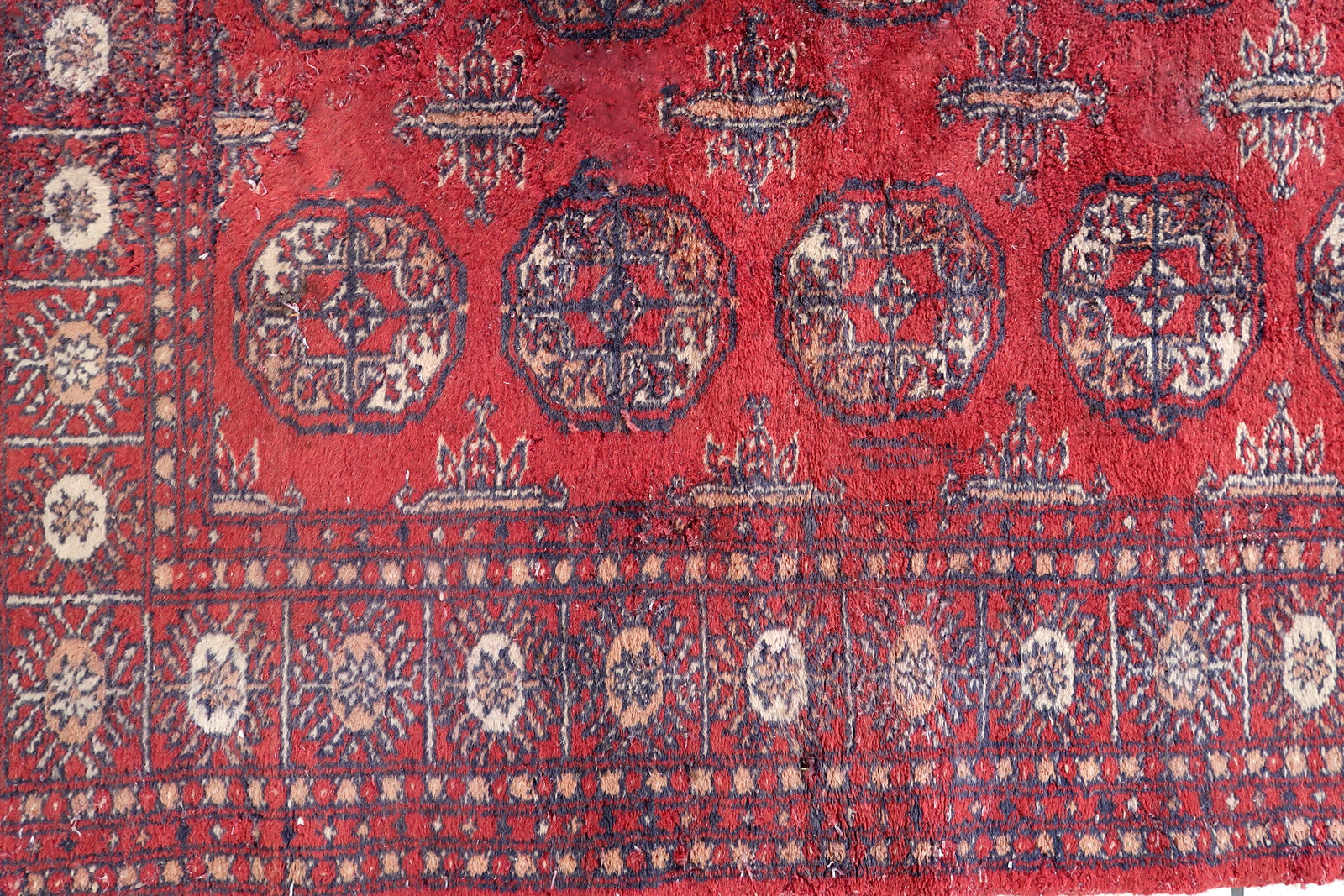 Handmade vintage Uzbek Bukhara rug in bright red color. The rug is from the end of 20th century in good condition, it has some signs of age and old restorations.