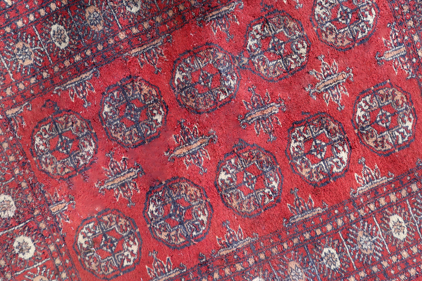 Handmade vintage Uzbek Bukhara rug in bright red color. The rug is from the end of 20th century in good condition, it has some signs of age and old restorations.