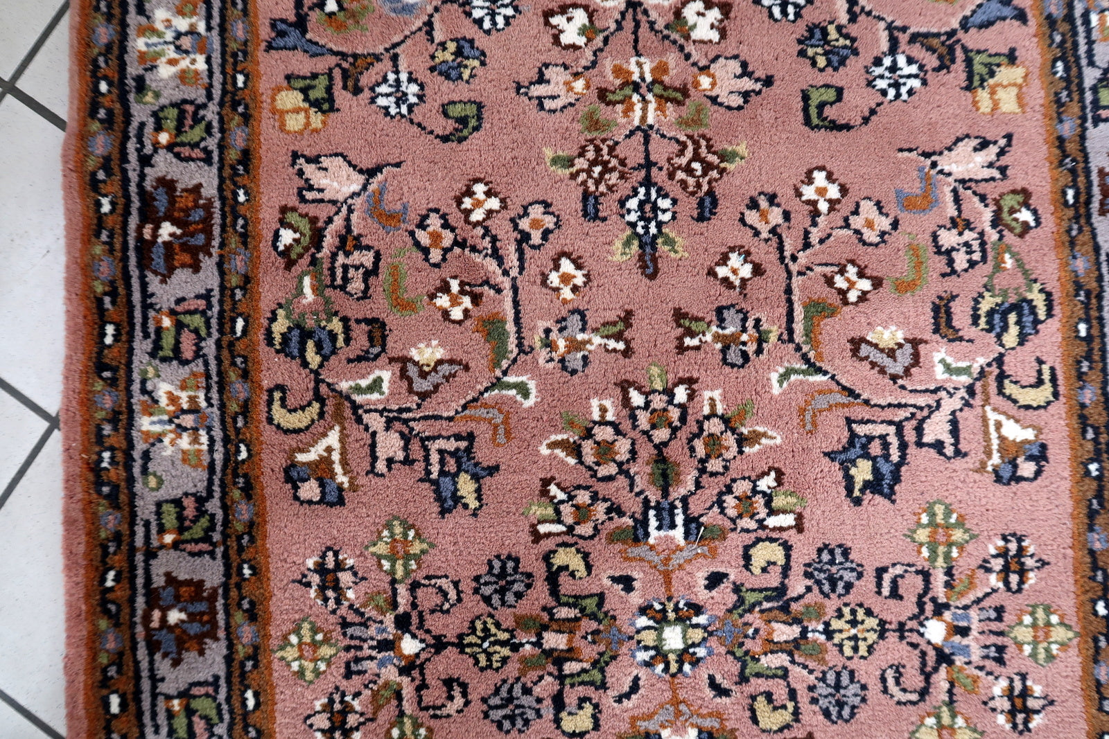 Handmade vintage Indian Seraband rug with floral design and pstel red shade. The rug is from the end of 20th century in original good condition.
