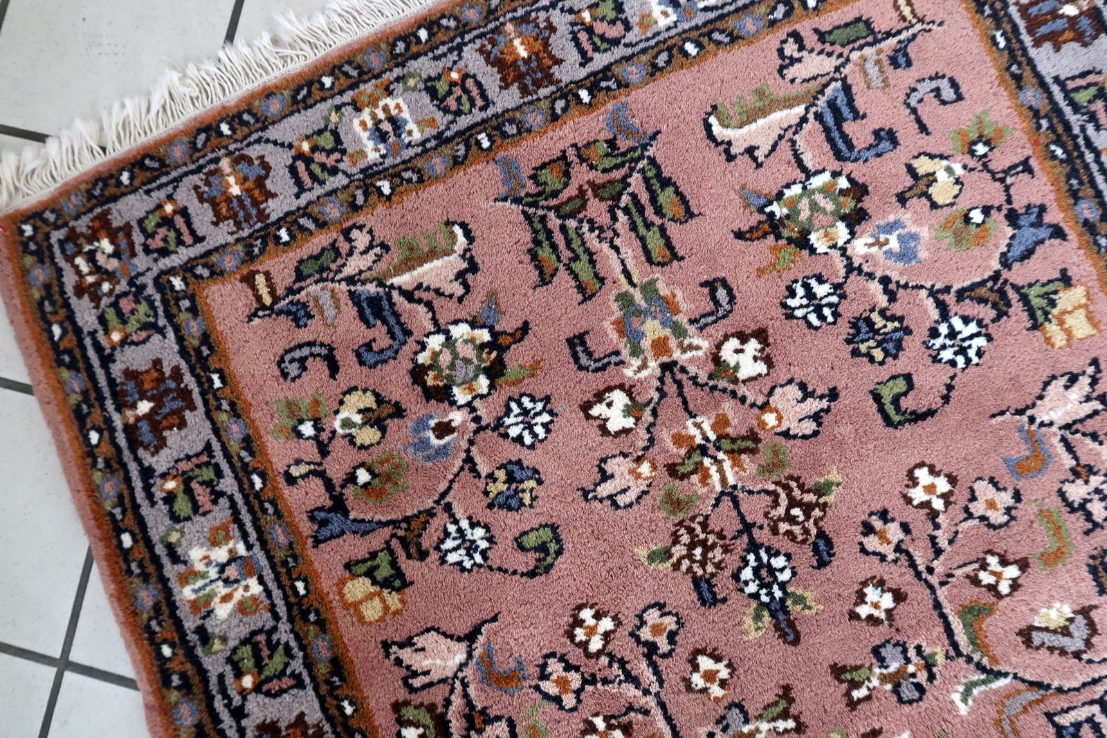 Handmade vintage Indian Seraband rug with floral design and pstel red shade. The rug is from the end of 20th century in original good condition.