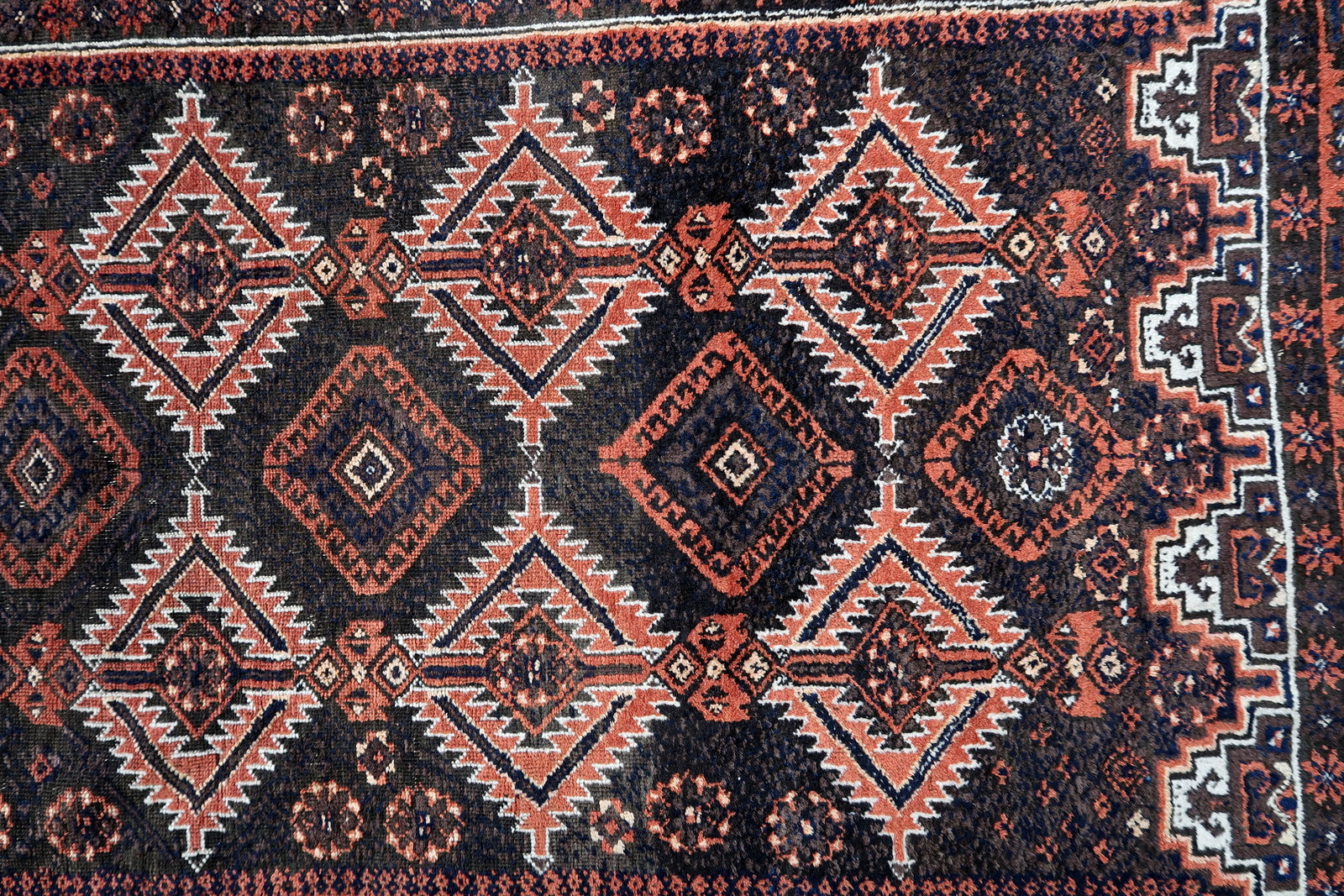 Handmade antique Afghan Baluch rug in traditional tribal design. The rug is from the beginning of 20th century in original condition, it yhas some minimal low pile.