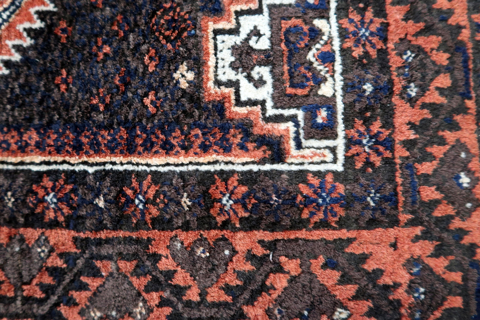 Handmade antique Afghan Baluch rug in traditional tribal design. The rug is from the beginning of 20th century in original condition, it yhas some minimal low pile.