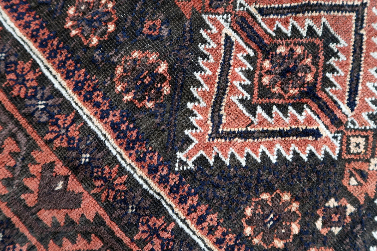 Handmade antique Afghan Baluch rug in traditional tribal design. The rug is from the beginning of 20th century in original condition, it yhas some minimal low pile.
