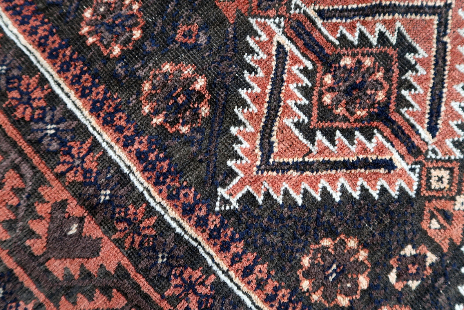 Handmade antique Afghan Baluch rug in traditional tribal design. The rug is from the beginning of 20th century in original condition, it yhas some minimal low pile.