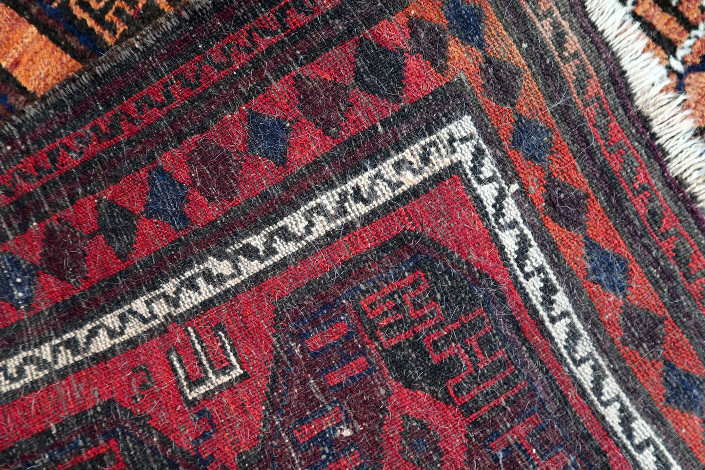 Handmade antique Afghan Baluch rug in repeating pattern. The rug is from the beginning of 20th century in original condition, it has some low pile.