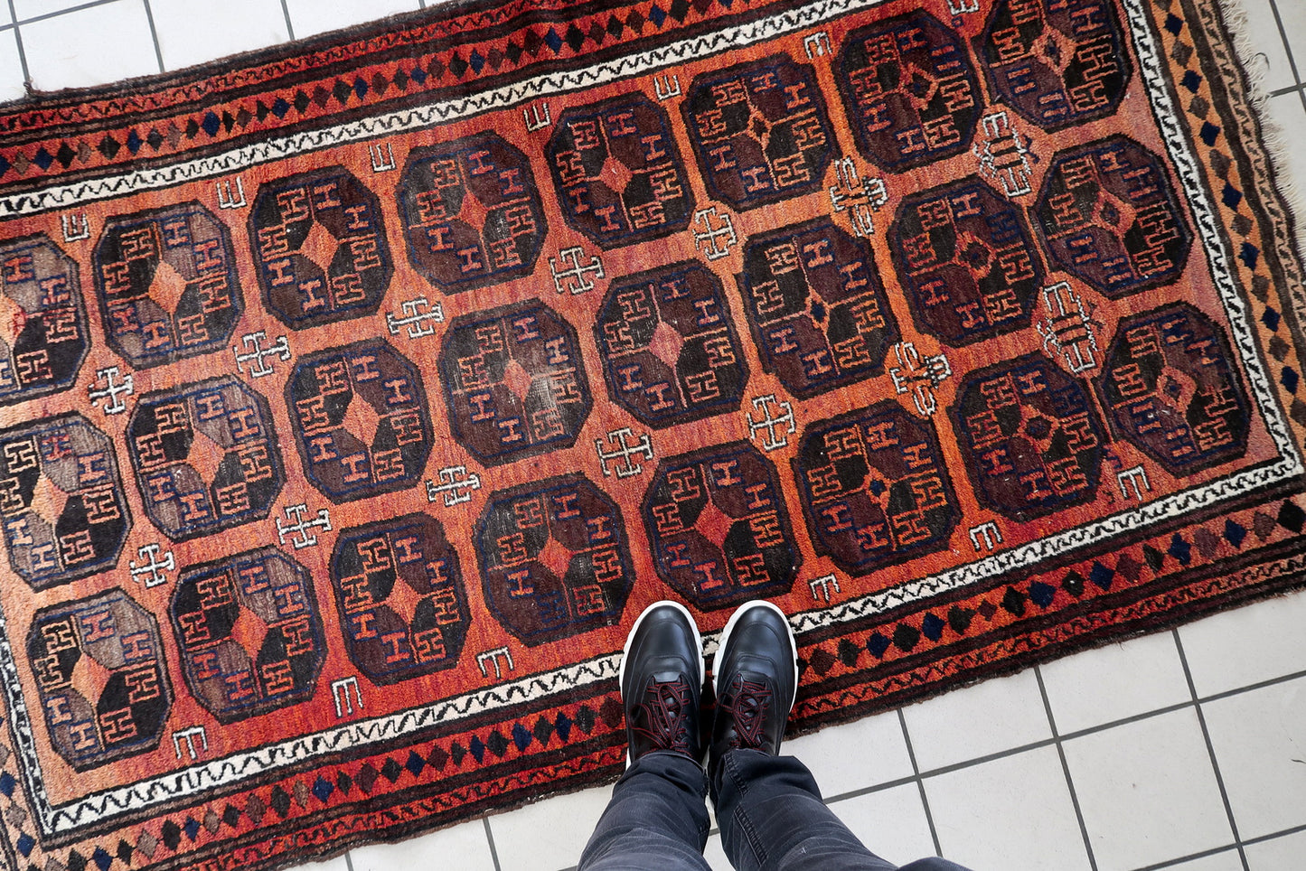 Handmade antique Afghan Baluch rug in repeating pattern. The rug is from the beginning of 20th century in original condition, it has some low pile.