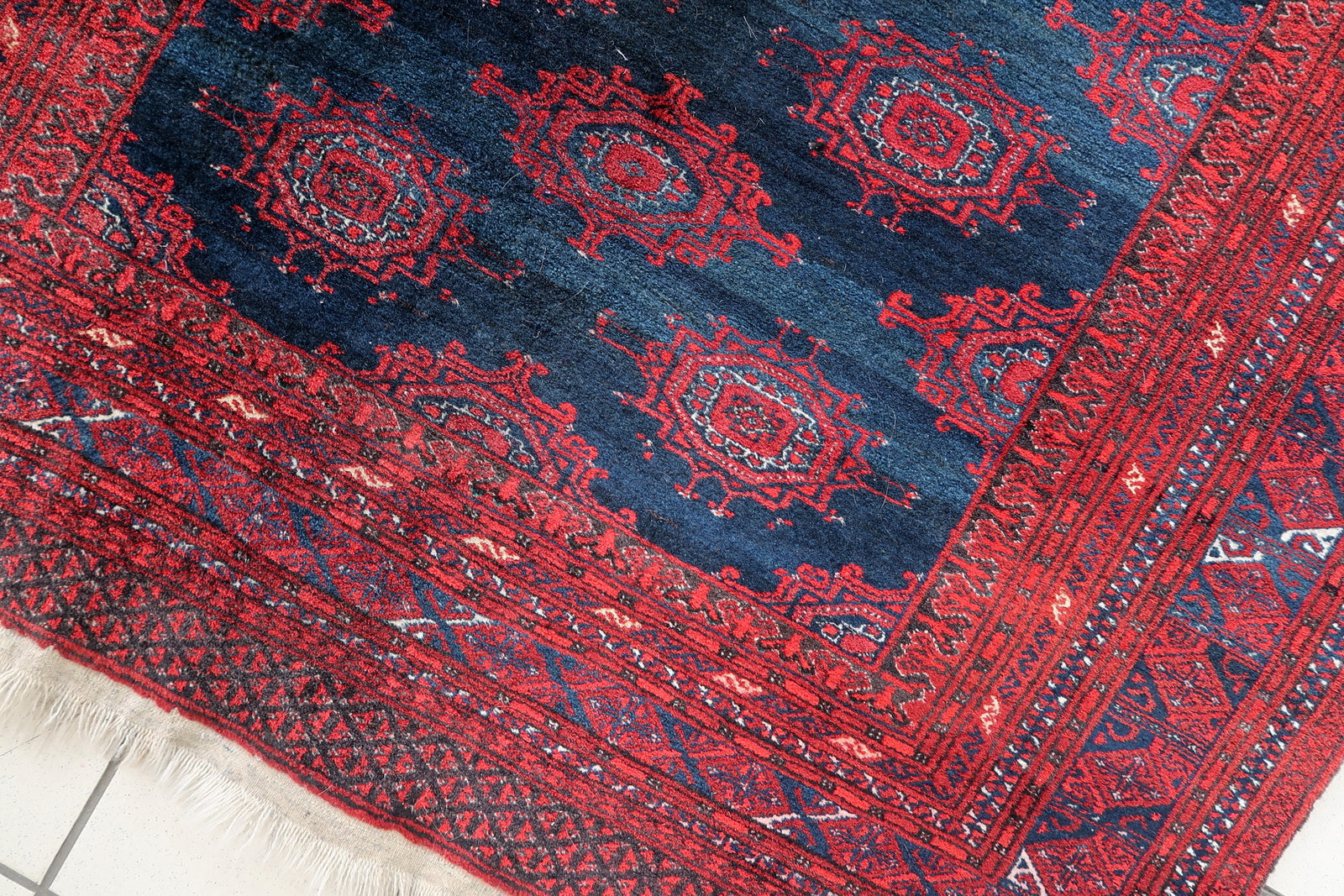 Handmade vintage Afghan Baluch rug in bright red and dark blue shades. The rug is from the middle of 20th century in original good condition.