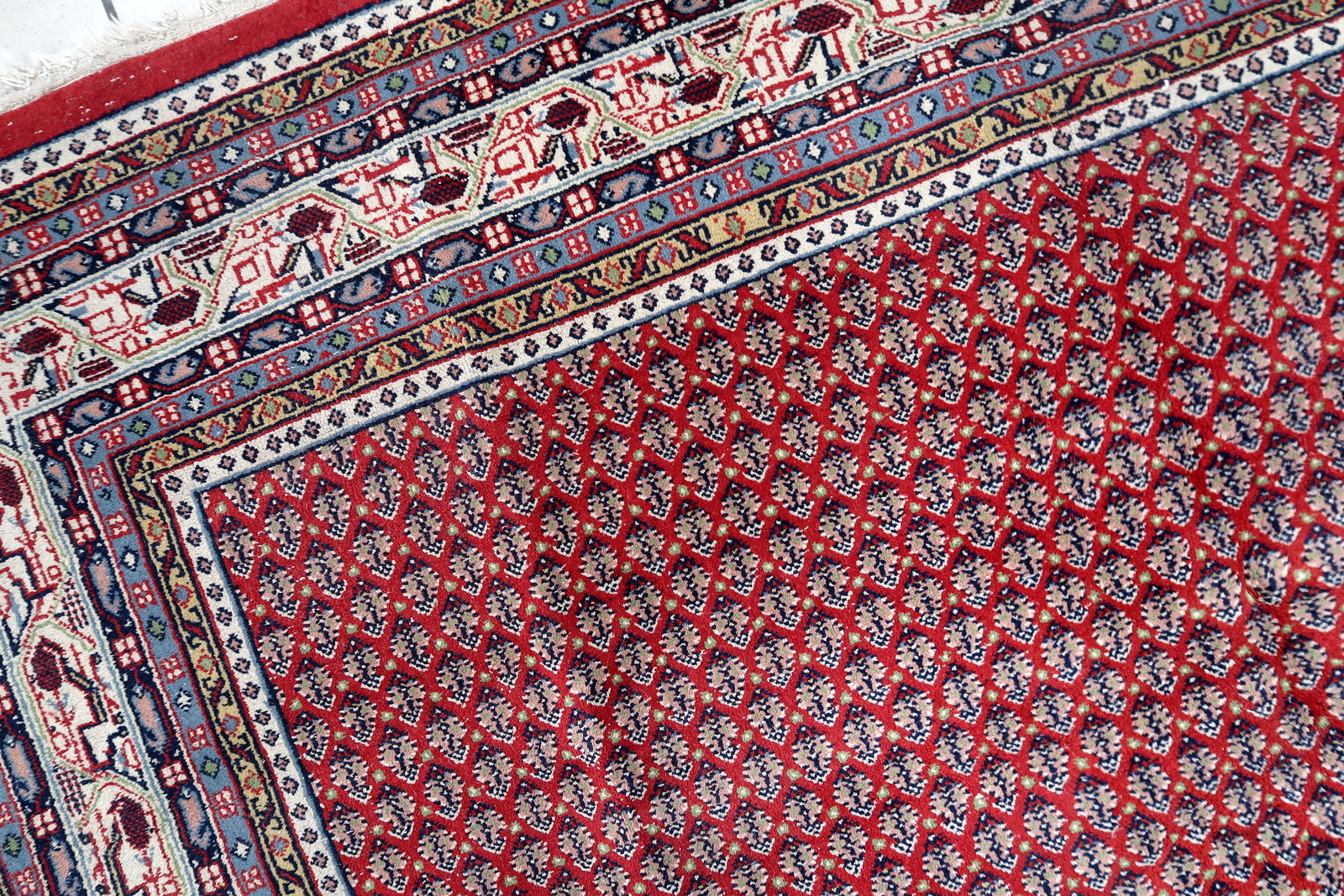 Handmade vintage Indian Seraband rug in repeating pattern and red shade. The rug is from the end of 20th century in original good condition.