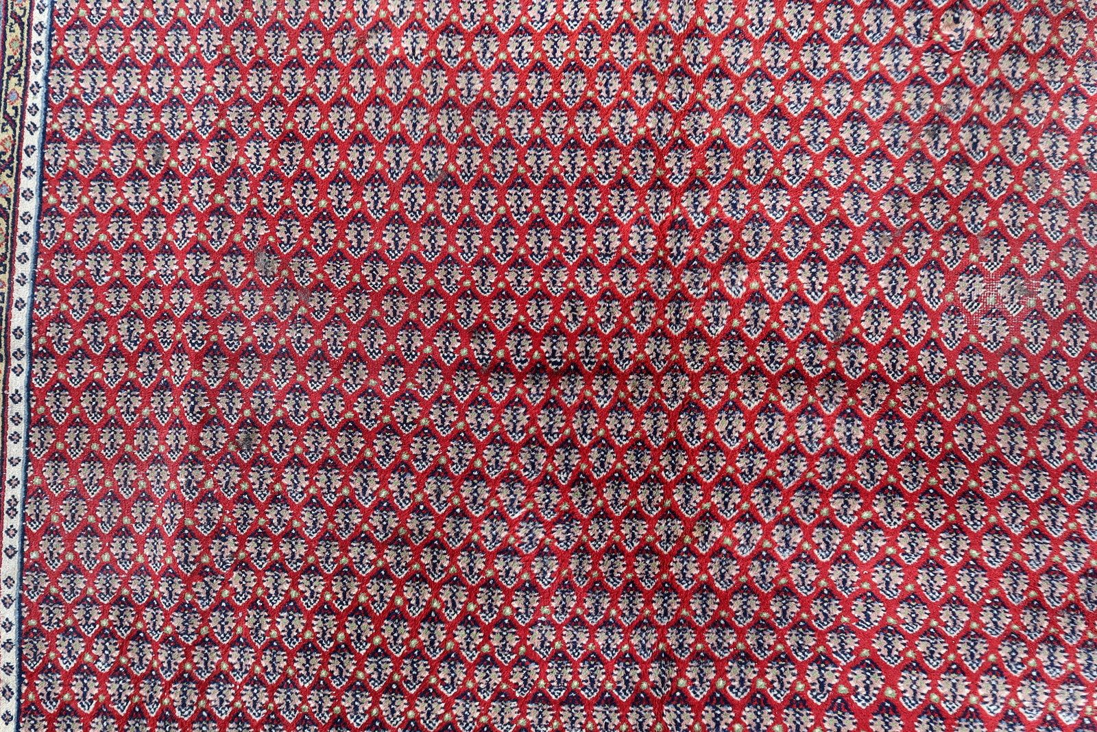 Handmade vintage Indian Seraband rug in repeating pattern and red shade. The rug is from the end of 20th century in original good condition.