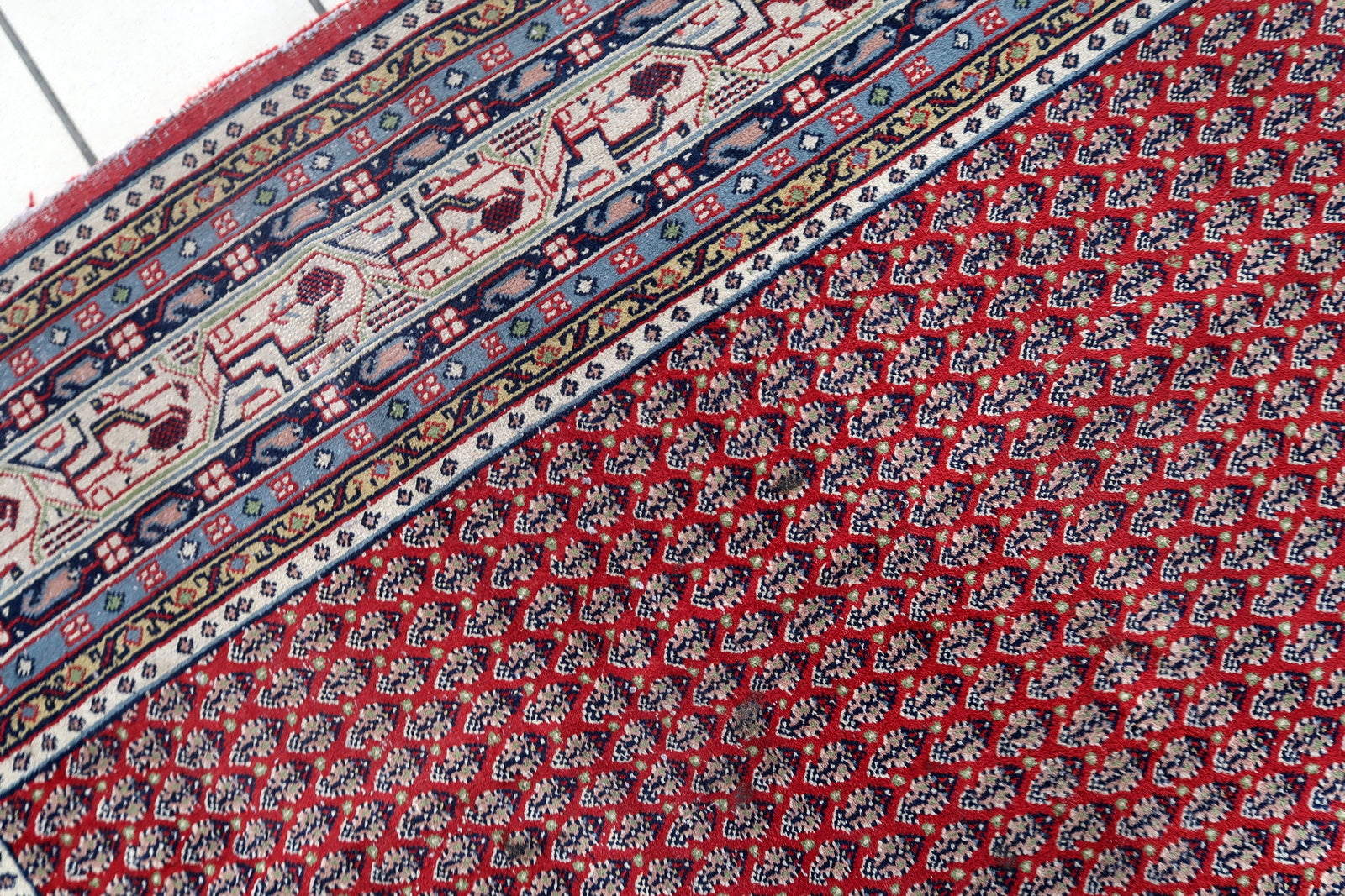 Handmade vintage Indian Seraband rug in repeating pattern and red shade. The rug is from the end of 20th century in original good condition.