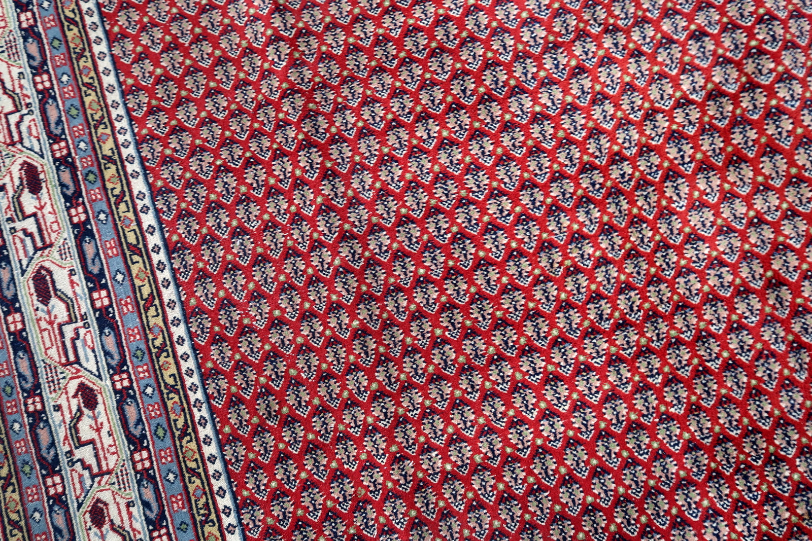 Handmade vintage Indian Seraband rug in repeating pattern and red shade. The rug is from the end of 20th century in original good condition.