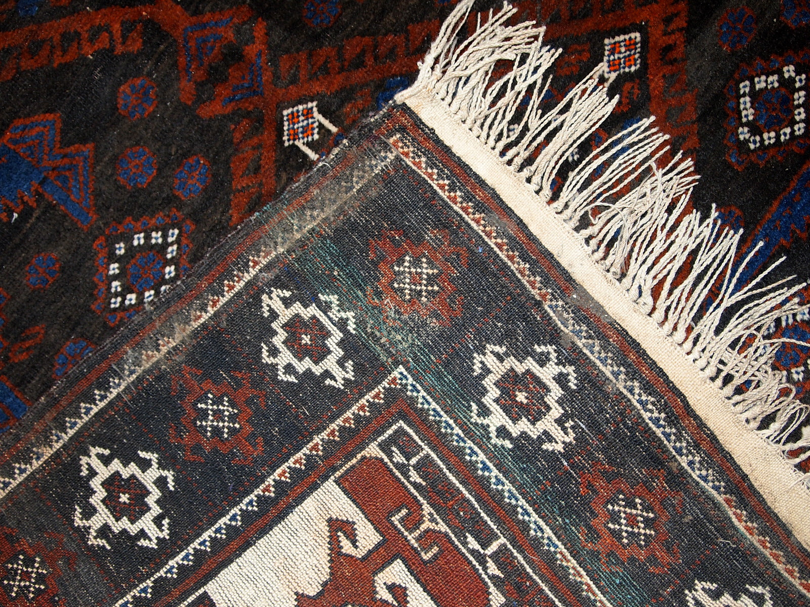 Detailed shot of the rug's corners and tribal motifs.