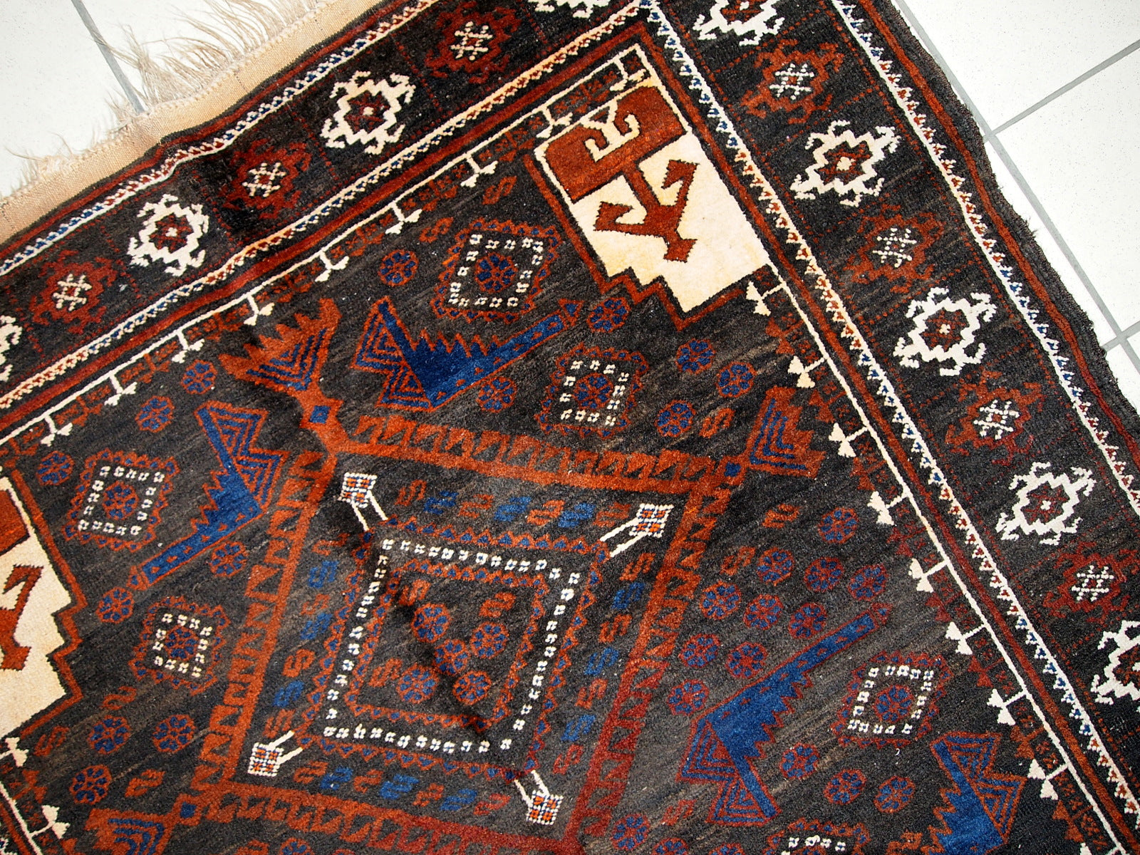 Detailed view of bright blue patterns and designs on the Afghan Baluch rug.