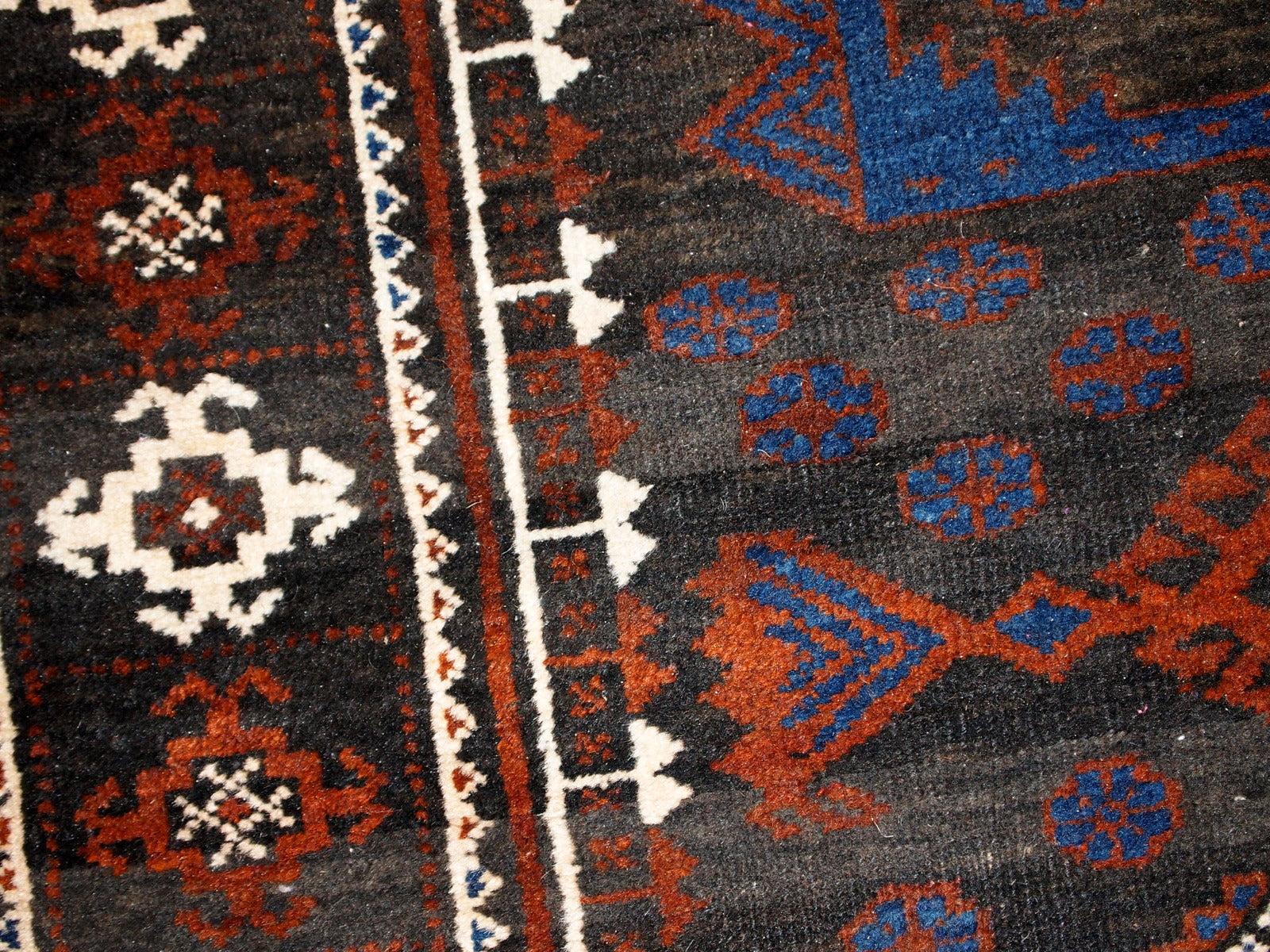 Intricate patterns and woolen texture of the Afghan Baluch rug.
