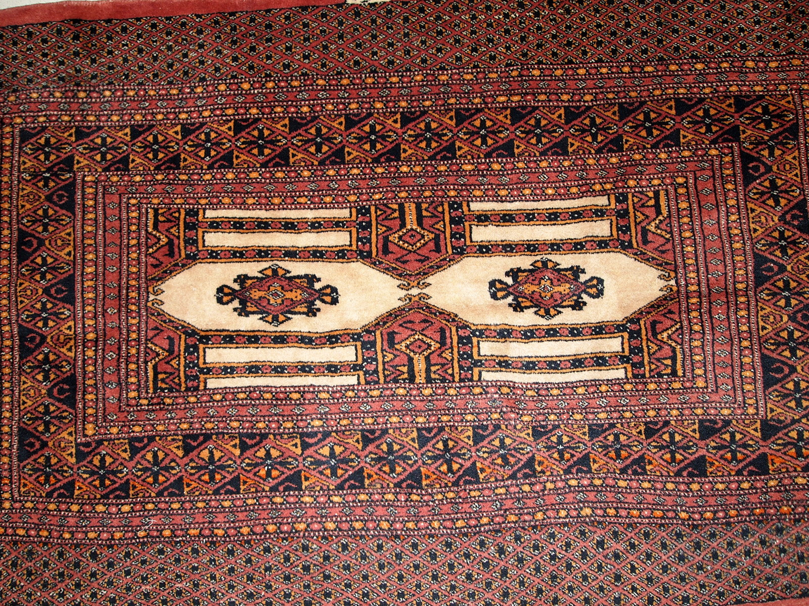 Detailed View of Orange Accents on the Rug