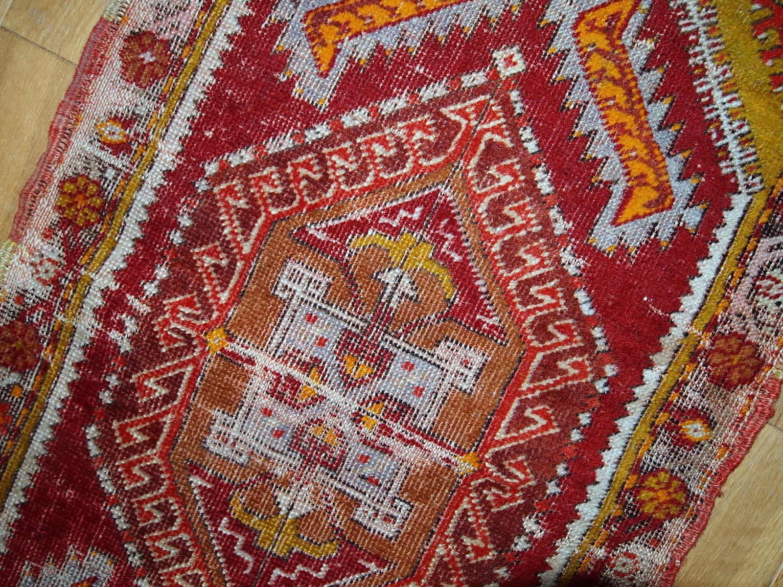 Antique Turkish Yastik rug in distressed condition. The rug made in red color with some accents of gold, orange and olive brown shades. 