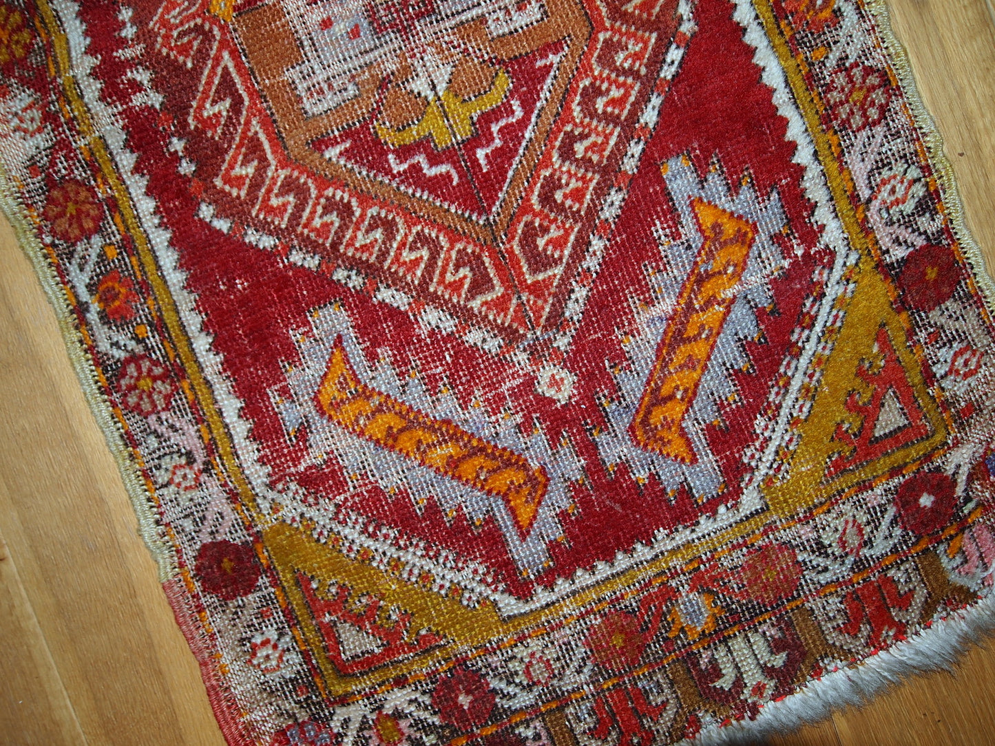 Antique Turkish Yastik rug in distressed condition. The rug made in red color with some accents of gold, orange and olive brown shades. 