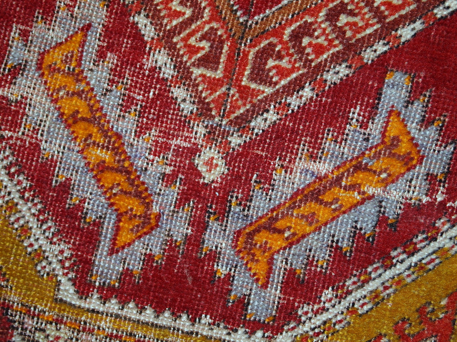 Antique Turkish Yastik rug in distressed condition. The rug made in red color with some accents of gold, orange and olive brown shades. 