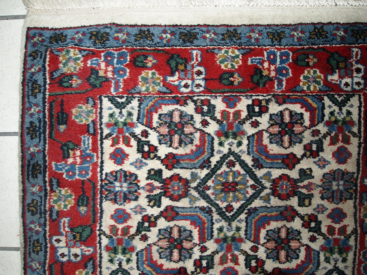 Vintage Indian Agra rug in original good condition. The rug made in white, blue and red shades.