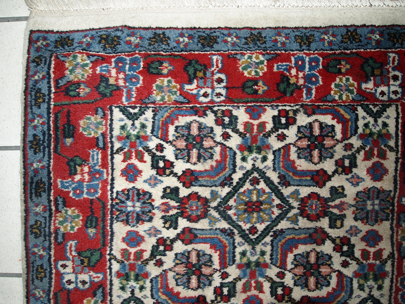 Vintage Indian Agra rug in original good condition. The rug made in white, blue and red shades.