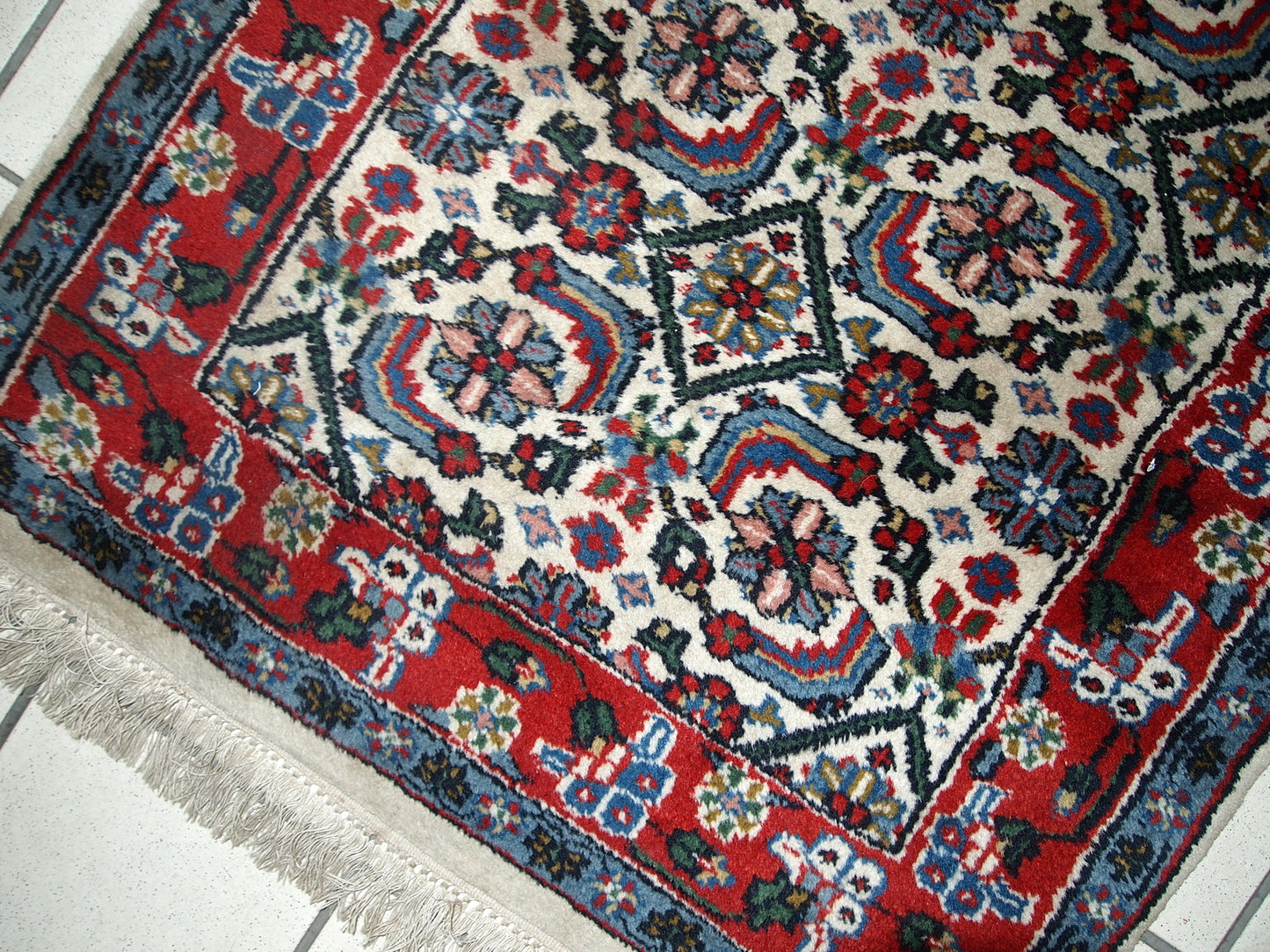 Vintage Indian Agra rug in original good condition. The rug made in white, blue and red shades.