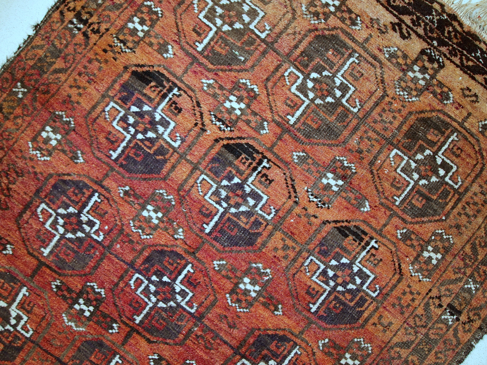 Antique hand made Afghan Baluch rug in original good condition. This rug is in brick red shade with repeating design.