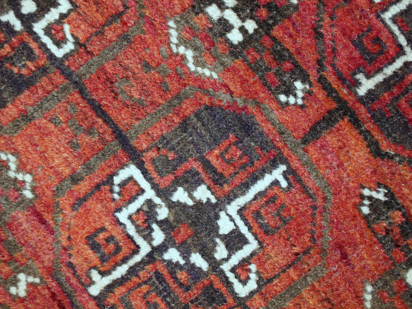 Antique hand made Afghan Baluch rug in original good condition. This rug is in brick red shade with repeating design.