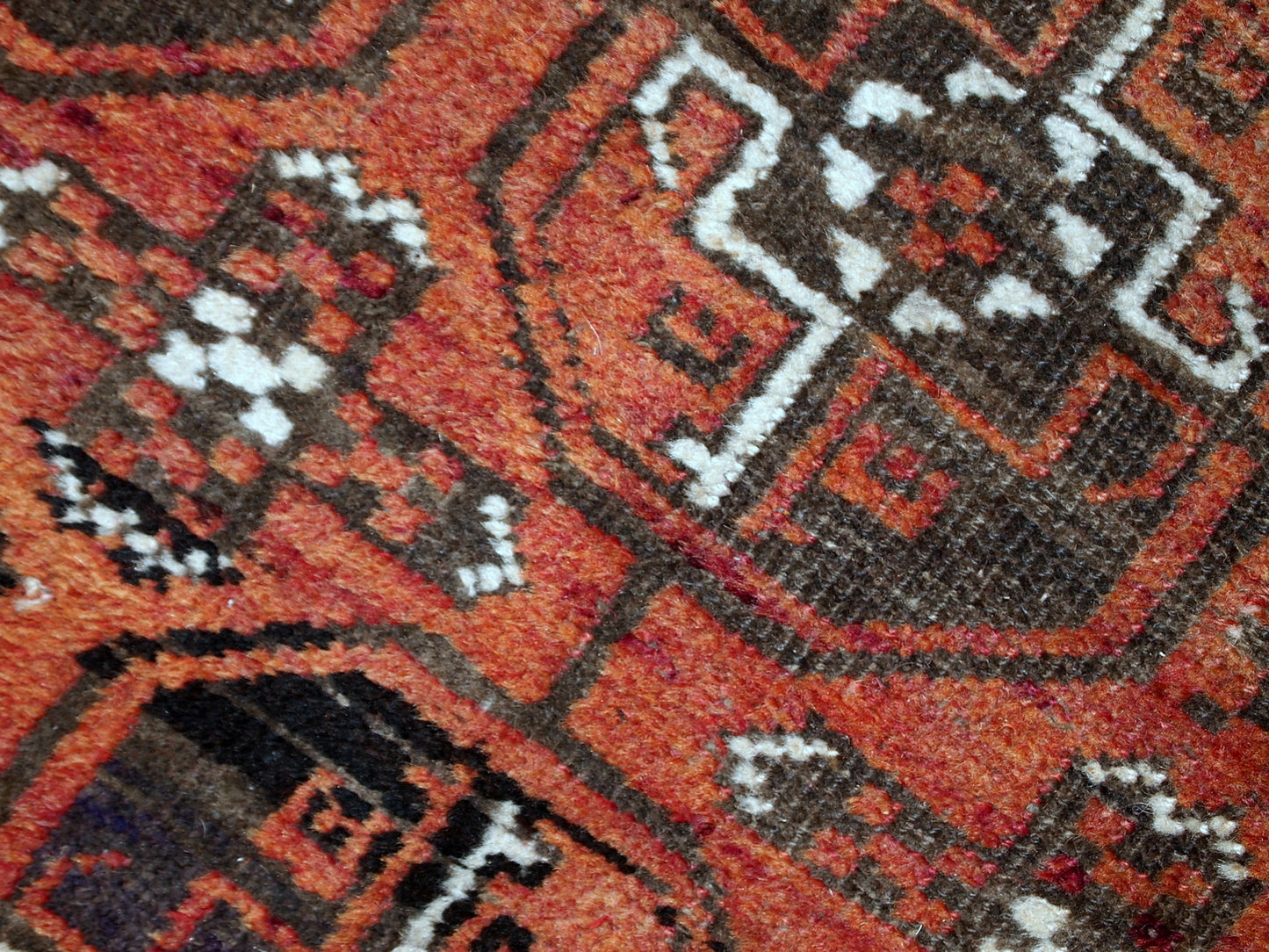 Antique hand made Afghan Baluch rug in original good condition. This rug is in brick red shade with repeating design.