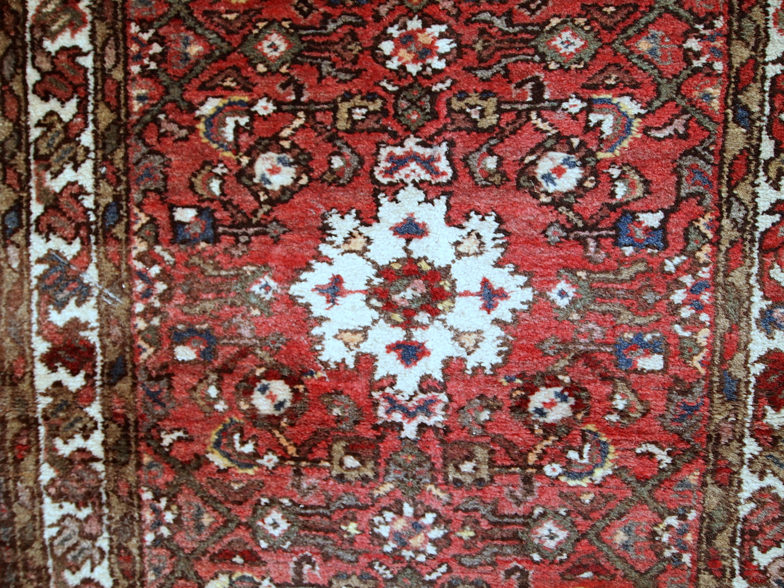 Vintage Persian Hamadan rug in good original condition. The rug is from the middle of 20th century made in red wool.