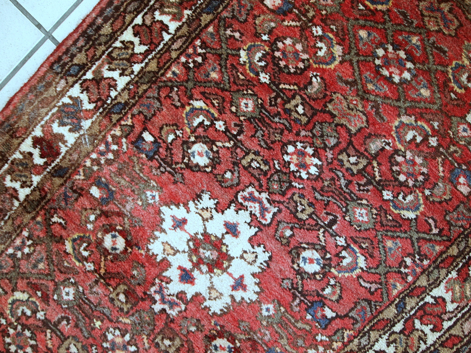 Vintage Persian Hamadan rug in good original condition. The rug is from the middle of 20th century made in red wool.