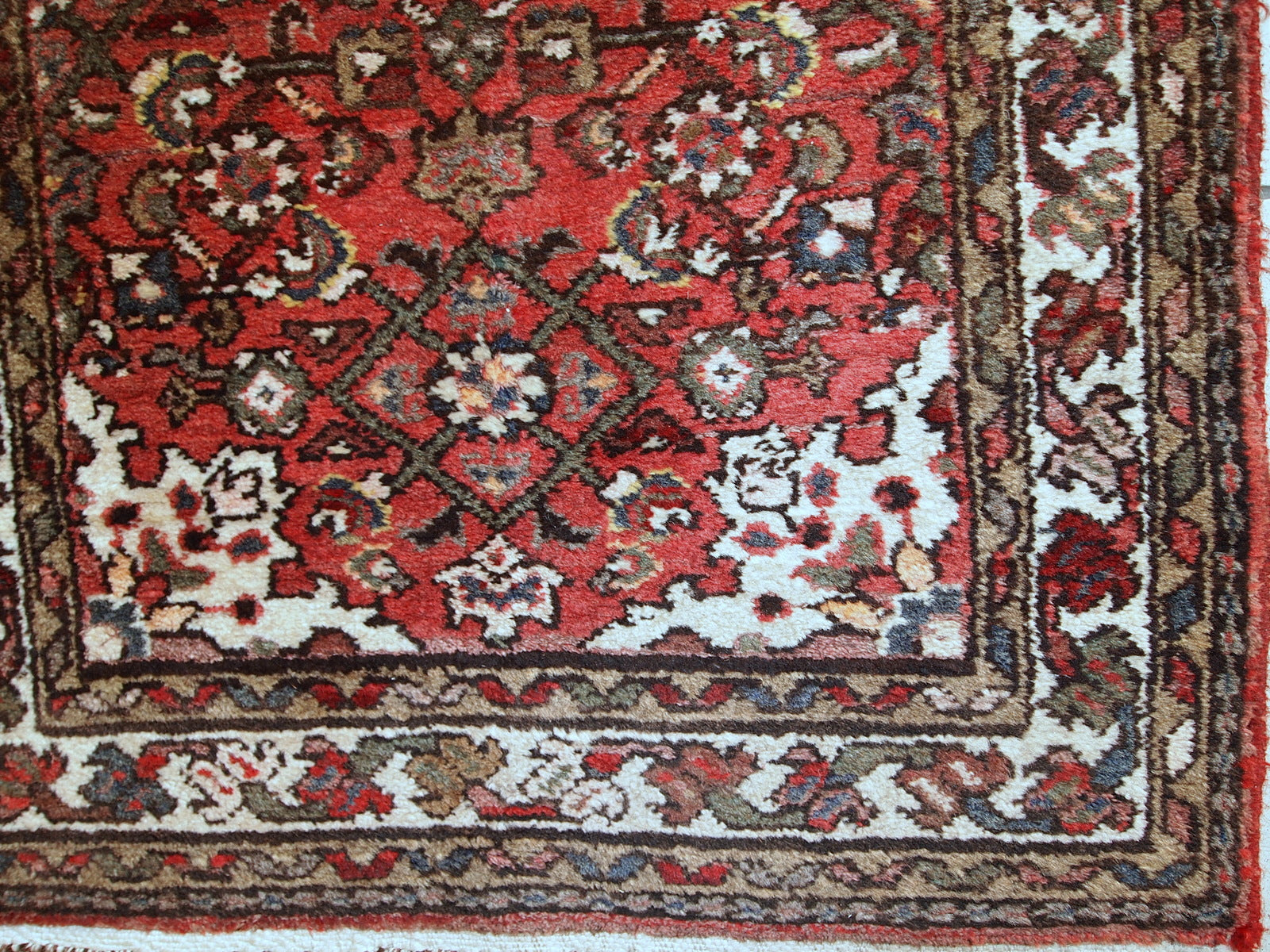 Vintage Persian Hamadan rug in good original condition. The rug is from the middle of 20th century made in red wool.