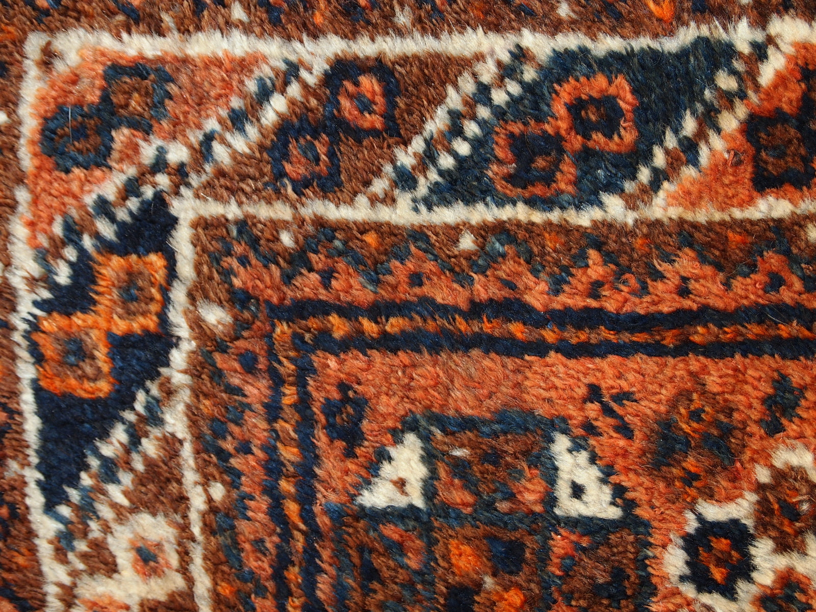 Antique collectible Persian Shiraz rug in original good condition. The rug is in rust shade with navy blue and white details. 