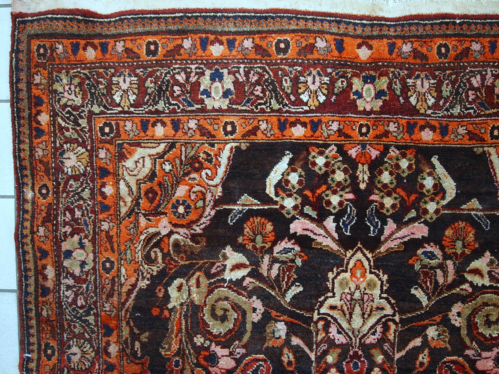 Vintage Persian Tabriz rug in original good condition. It is in chocolate brown and orange wool with some olive and pink shades.