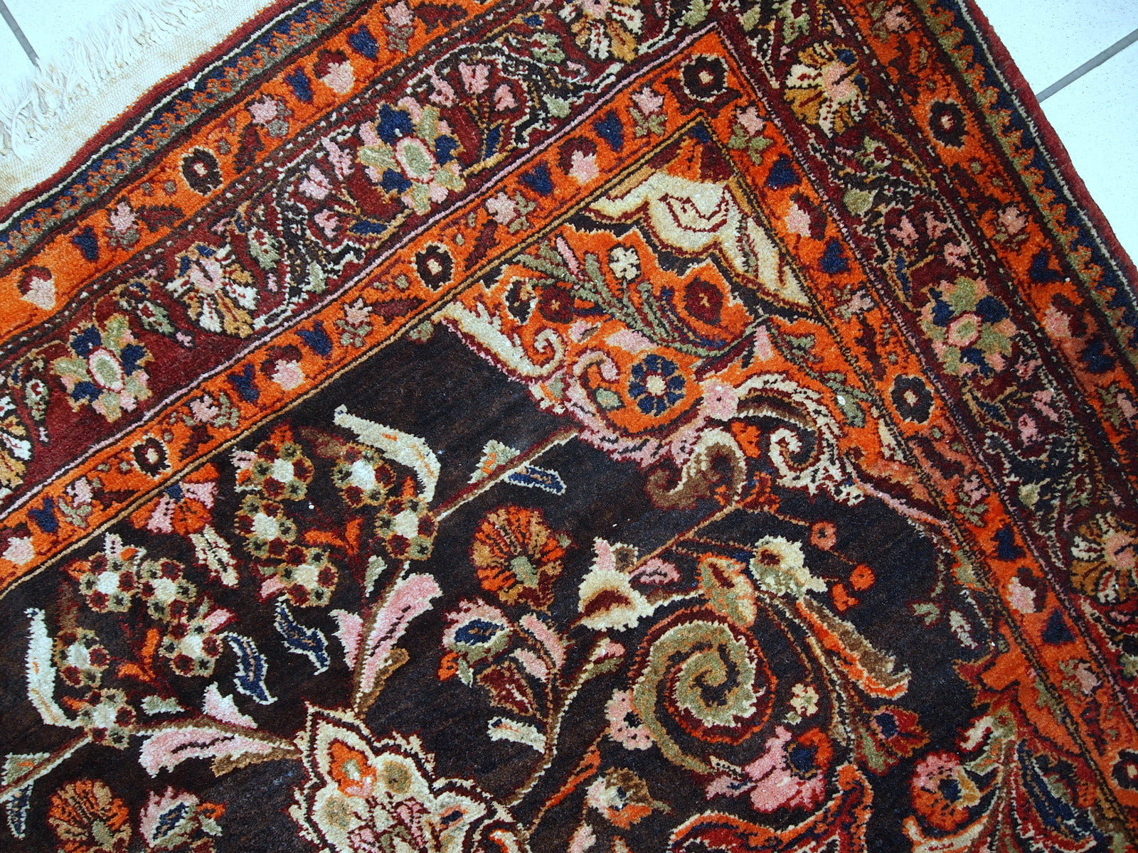 Vintage Persian Tabriz rug in original good condition. It is in chocolate brown and orange wool with some olive and pink shades.