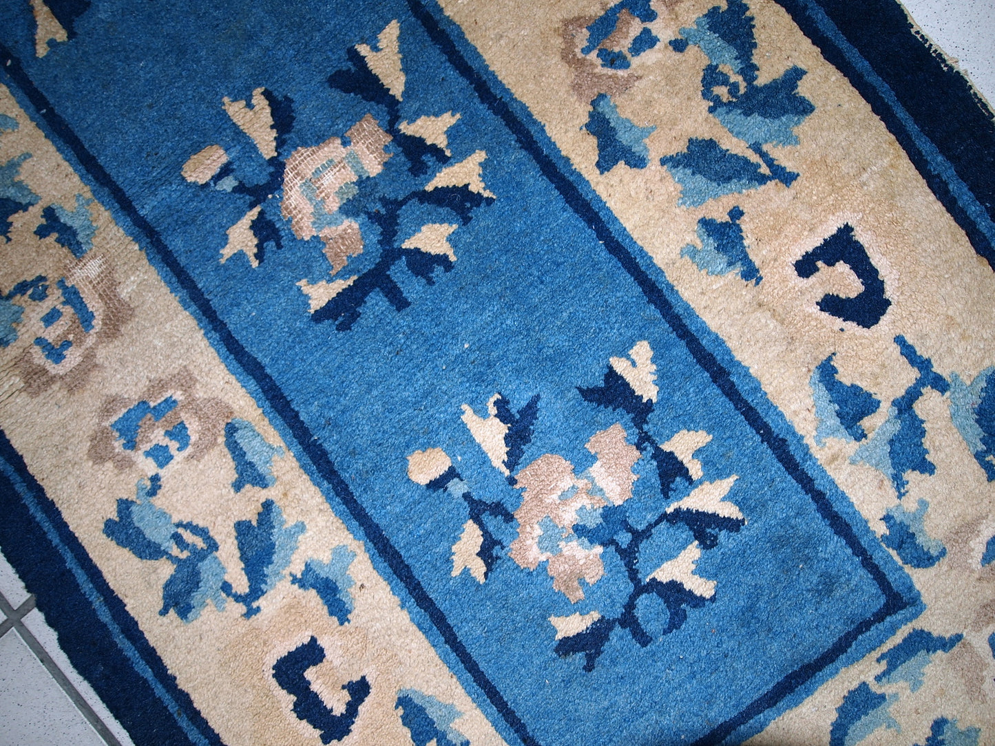 Detailed view of the beige elements in the rug's composition