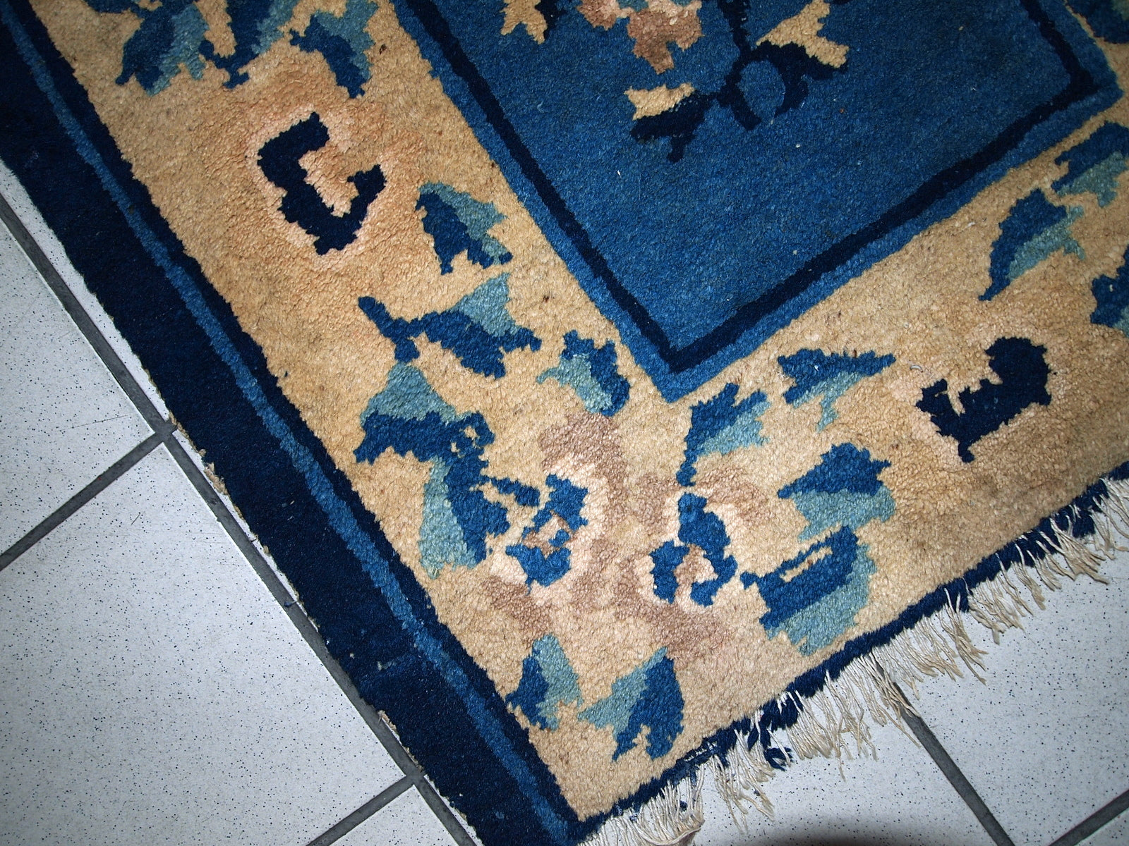 Close-up of the damaged parts on one end of the rug.