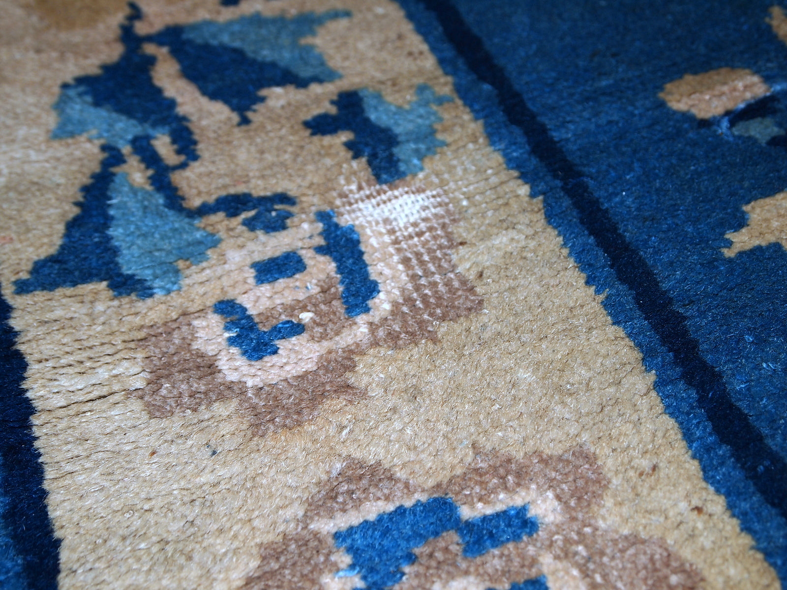 Detailed view of the partially damaged second end of the rug.
