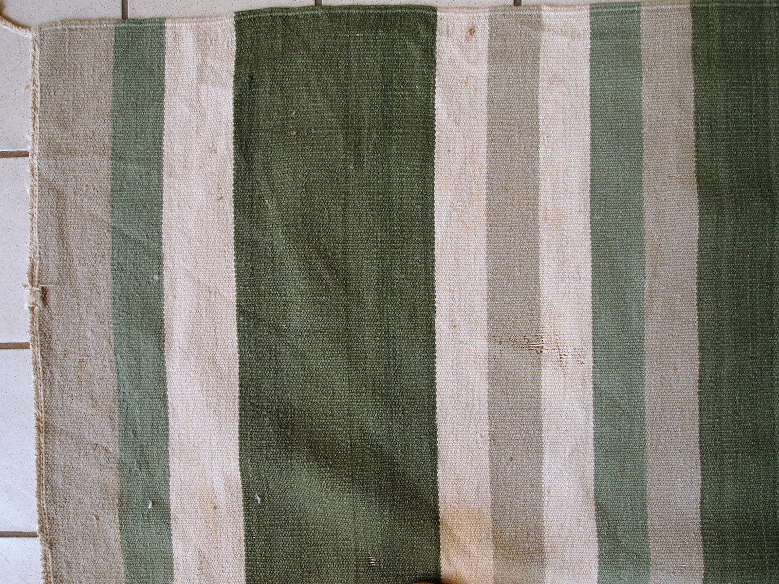 This kilim has very simple stripes motive in dark green, white and grey shades. It is in original condition from the beginning of 20th century, has some stains.