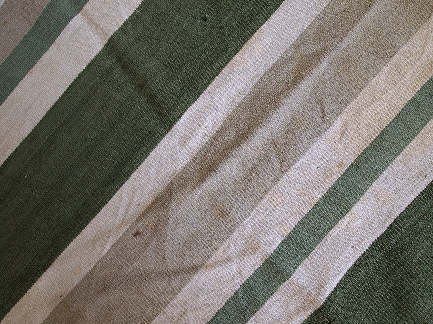 This kilim has very simple stripes motive in dark green, white and grey shades. It is in original condition from the beginning of 20th century, has some stains.