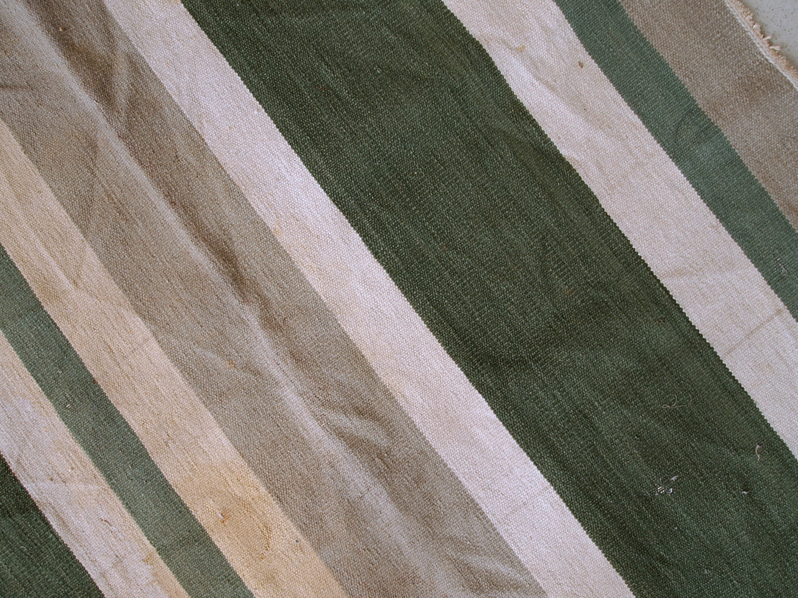 This kilim has very simple stripes motive in dark green, white and grey shades. It is in original condition from the beginning of 20th century, has some stains.