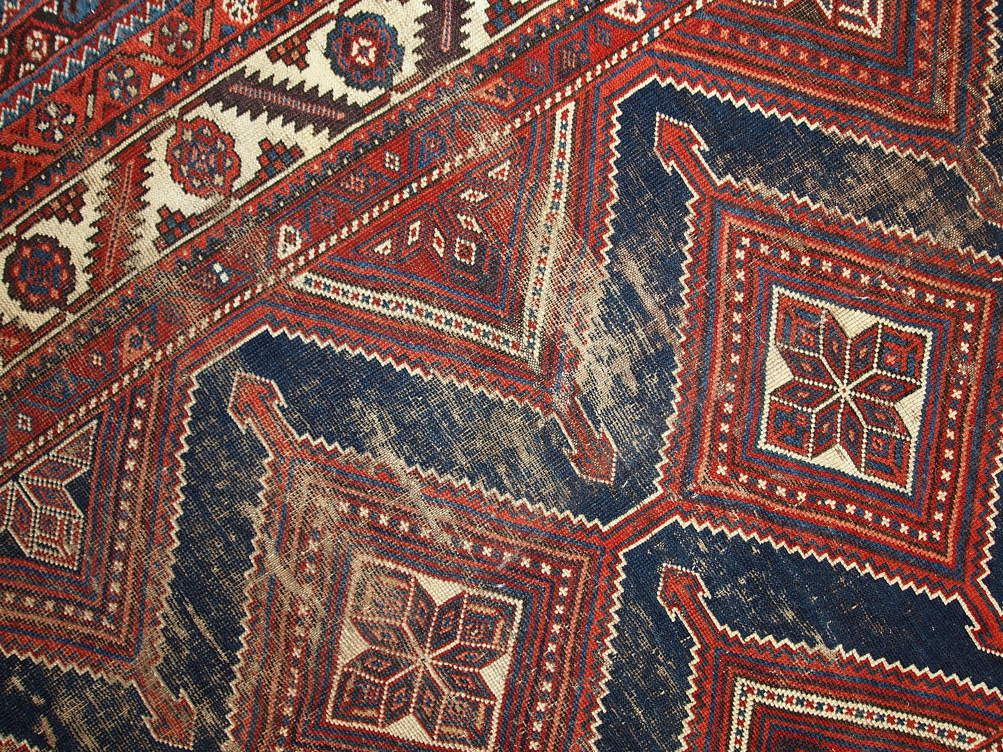 Antique Persian Shiraz rug in distressed condition. The rug made in traditional tribal design in the beginning of 20th century.