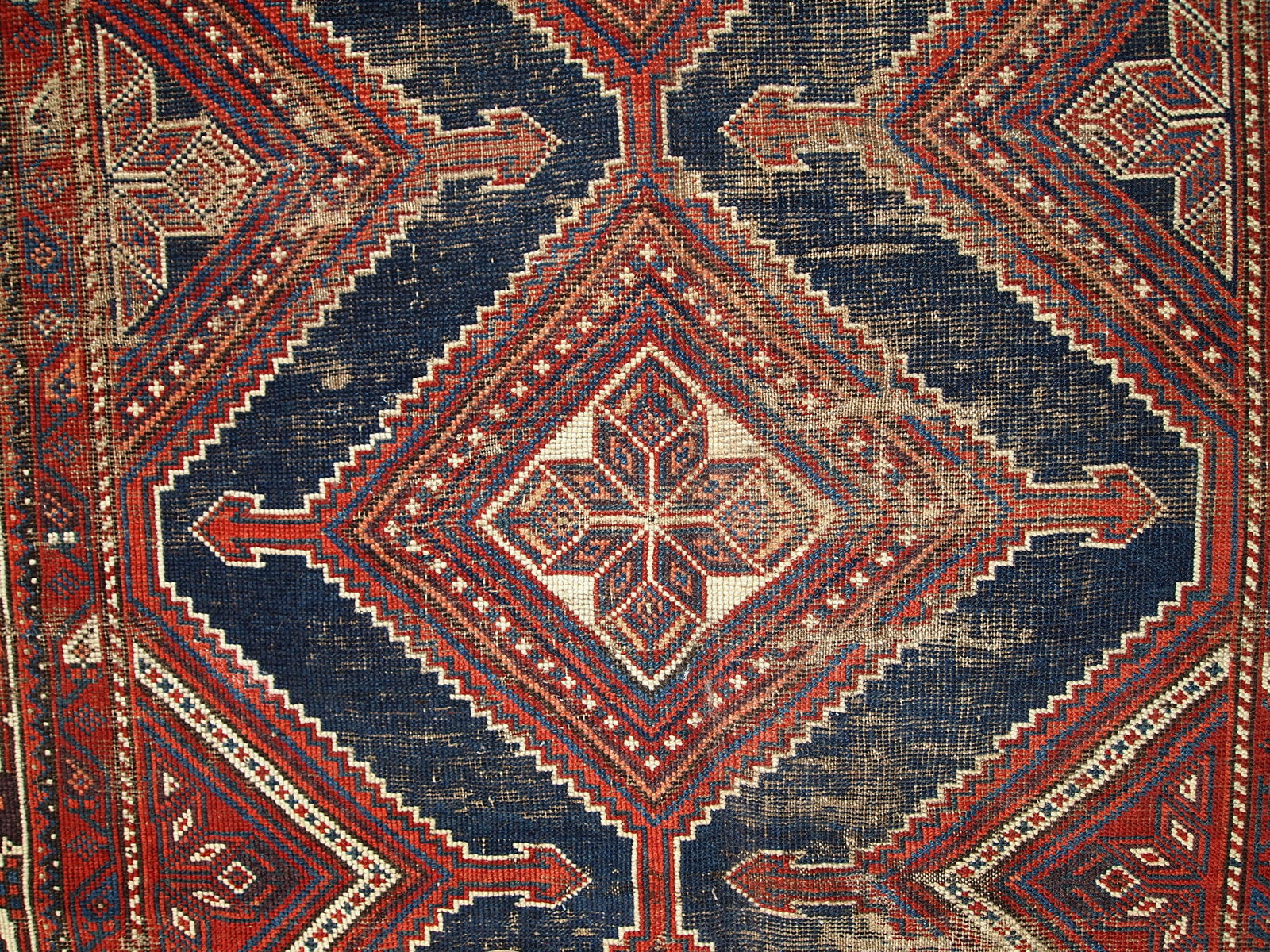 Antique Persian Shiraz rug in distressed condition. The rug made in traditional tribal design in the beginning of 20th century.