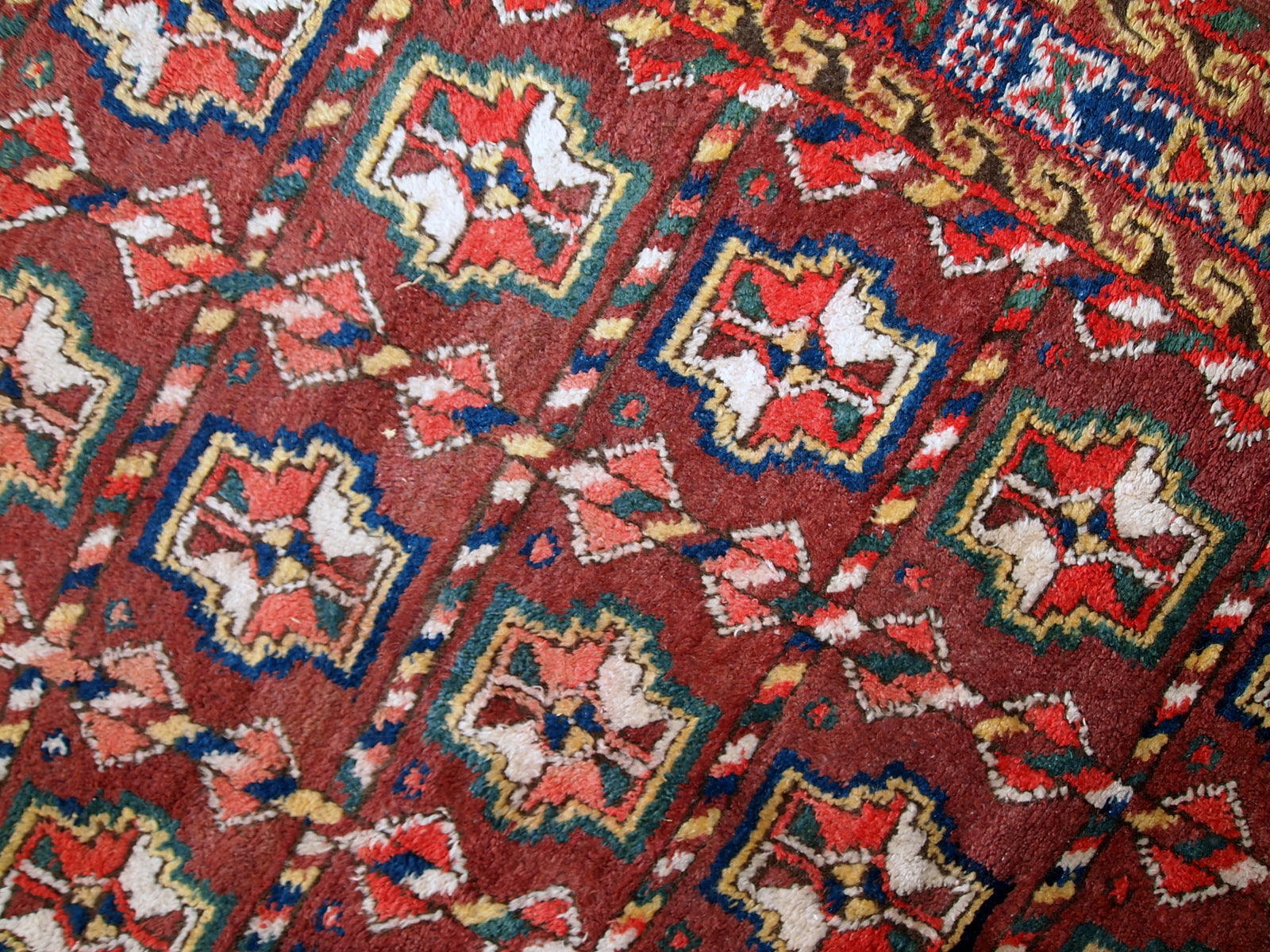 This antique Kurdish rug made in deep shade of burgundy. All-over design with geometric and tribal accents. The wool on the rug is soft, it is in original good condition.