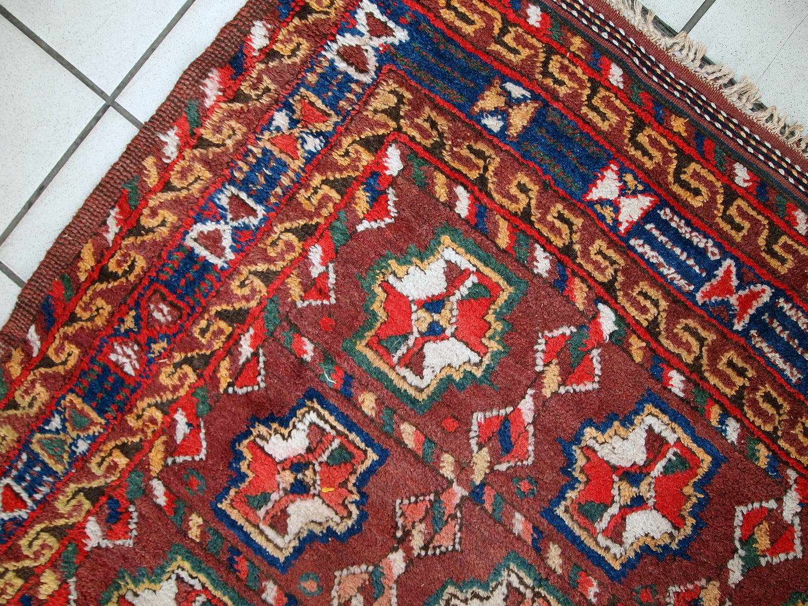 This antique Kurdish rug made in deep shade of burgundy. All-over design with geometric and tribal accents. The wool on the rug is soft, it is in original good condition.