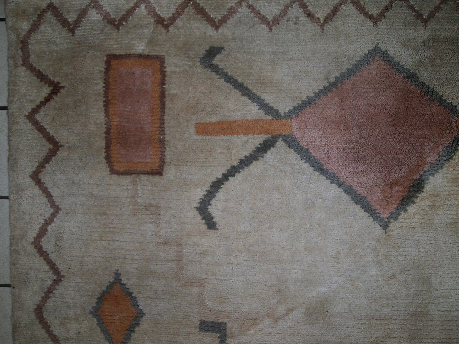 Handmade vintage Tibetan Khaden rug in original good condition. The rug has full pile, made in geometric design in beige shade. The rug is heavy.