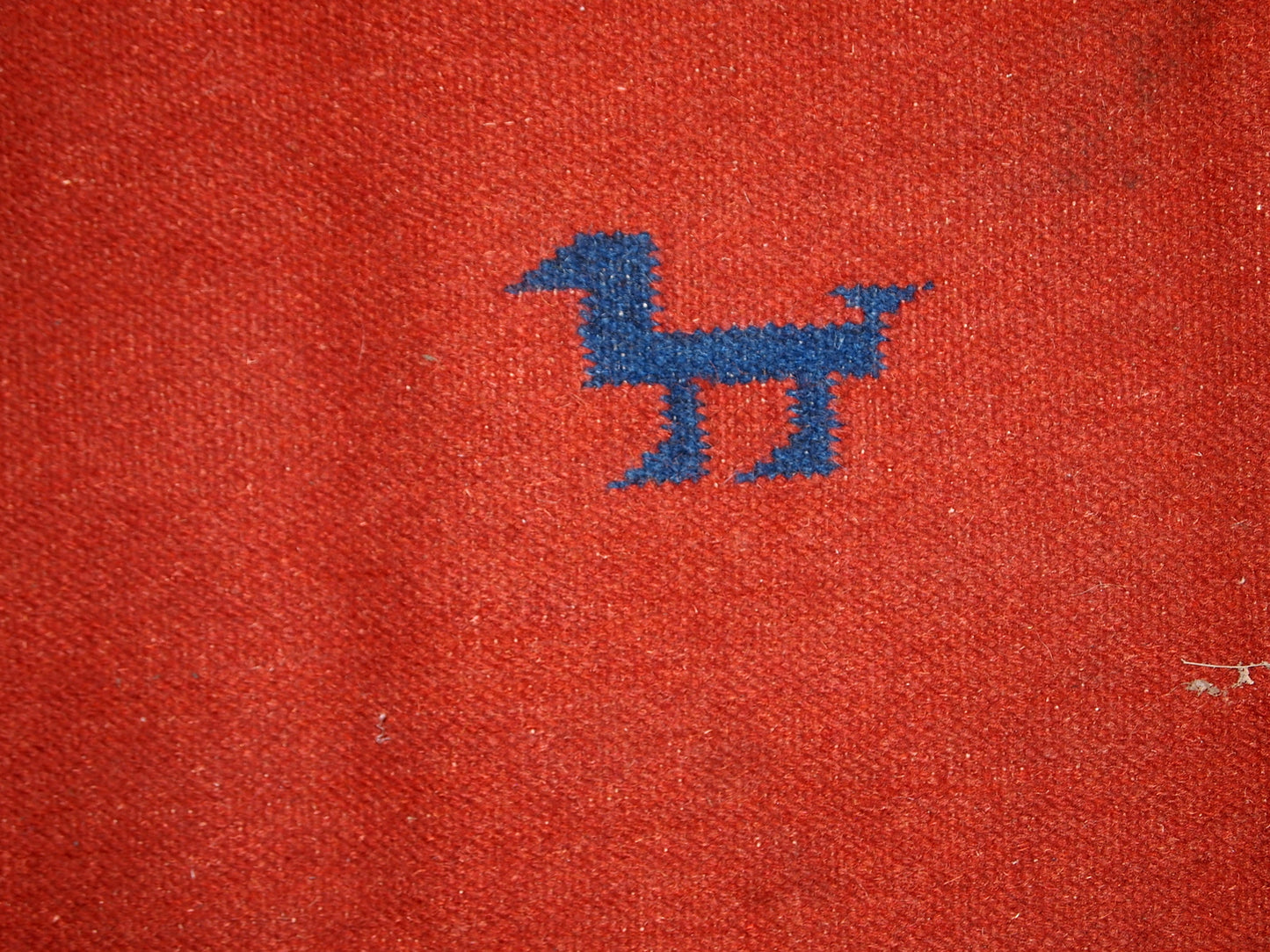 Mid-century Persian kilim in red shade and all-over design. Miniature animals are in navy blue shade along with border. Sky blue colors are in each corner. The kilim is generally in original good condition, one corner is missing.