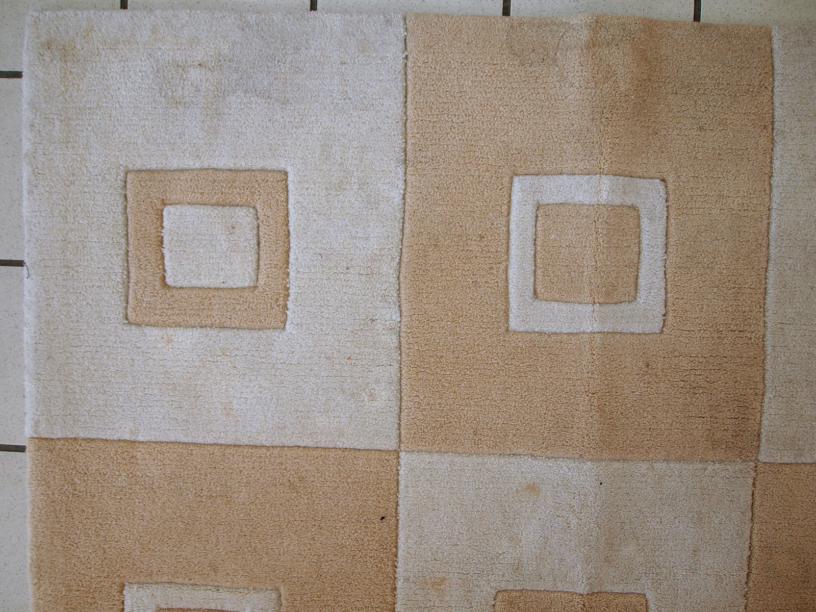 Handmade Chinese rug in light shades of white and brown. It has modern geometric design. The rug made out of acrylic in China. It is in original condition, has some age discolorations.
