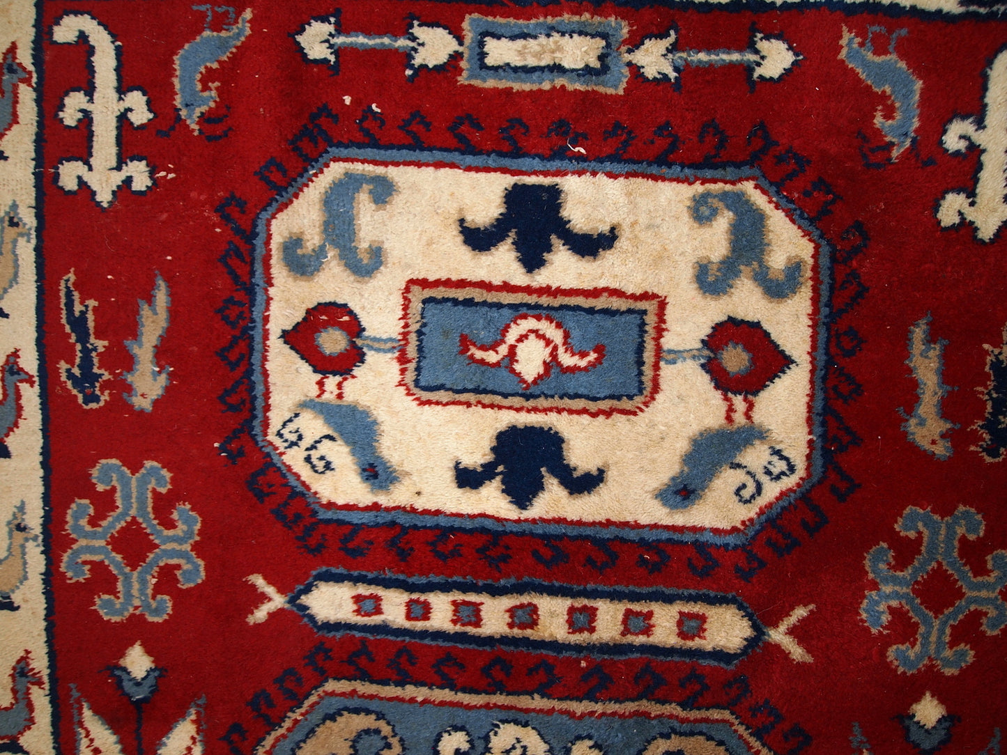 Handmade Russian vintage rug in deep red shade. The beige border decorated in roosters. Made out of wool, the rug is very thick and warm. It is in original good condition.