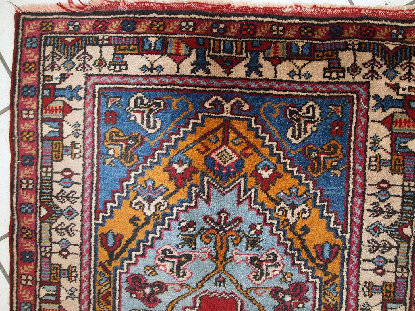This vintage prayer Turkish rug made in colorful shades of wool. The rug is quite thick and soft. Beautiful beige border with colorful houses on it. The rug is in original good condition.