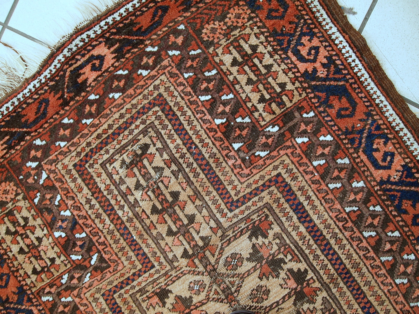 This prayer Baluch rug is in original condition, it has some little age wear and old restoration from the back. Light shade of brown on the field and red decorations. The border has beautiful tribal design in navy blue, pink and red. 